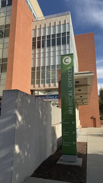 Hospital building with a green sign pointing to the hospital and Women & Children's