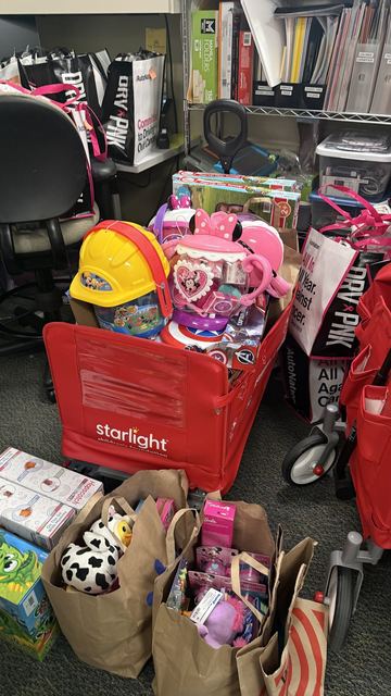 A red wagon and bags overflowing with toys, games, and a toy hard hat